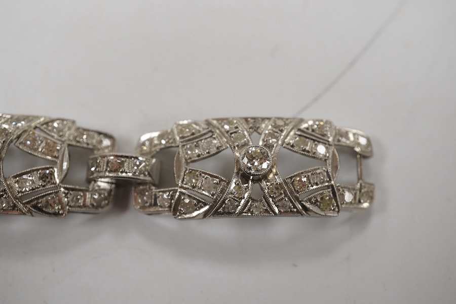 An early 20th century pierced platinum? and millegrain set diamond cluster bracelet, set with old round and eight cut stones, 17cm, gross weight 22.8 grams. Condition - fair to good